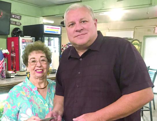 Carol Cooper (left), the owner of Zydeco's Restaurant in Belle Chasse, presents Robert Koch (right) of Gretna with a $100 restaurant gift card, which was raffled on Father's Day, Sunday, June 18.